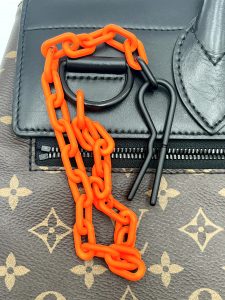 「ルイ・ヴィトンのバッグ」- 印象的なオレンジチェーン