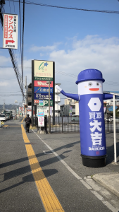 広島市佐伯区五日市中央の「買取大吉 五日市中央店」店舗外観。コイン通り沿いに位置し、大きな青い「大吉くん」のバルーンが目印です。