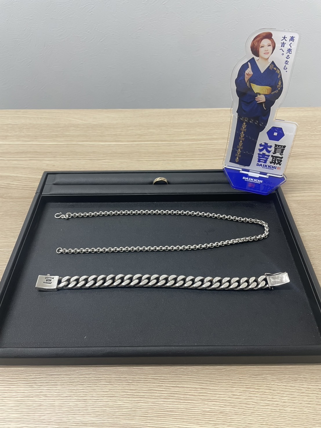 黒いトレーに並べた銀色のネックレスとブレスレット