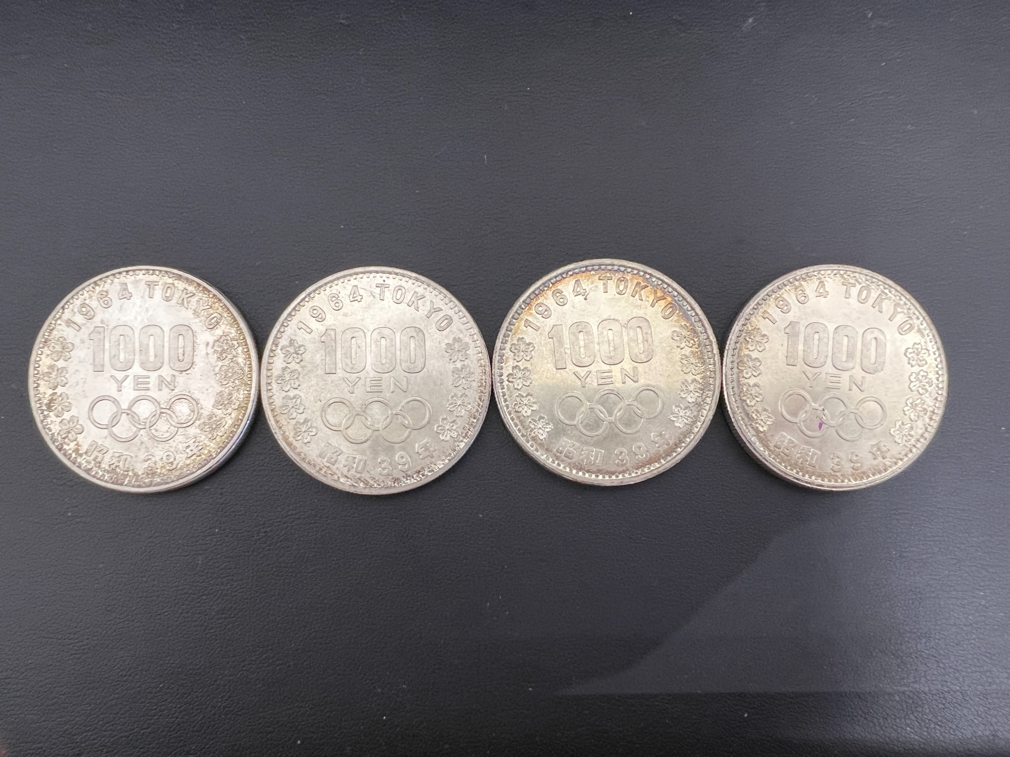 1964年東京オリンピック記念1,000円銀貨。五輪と桜の意匠、表面のくすみが見える