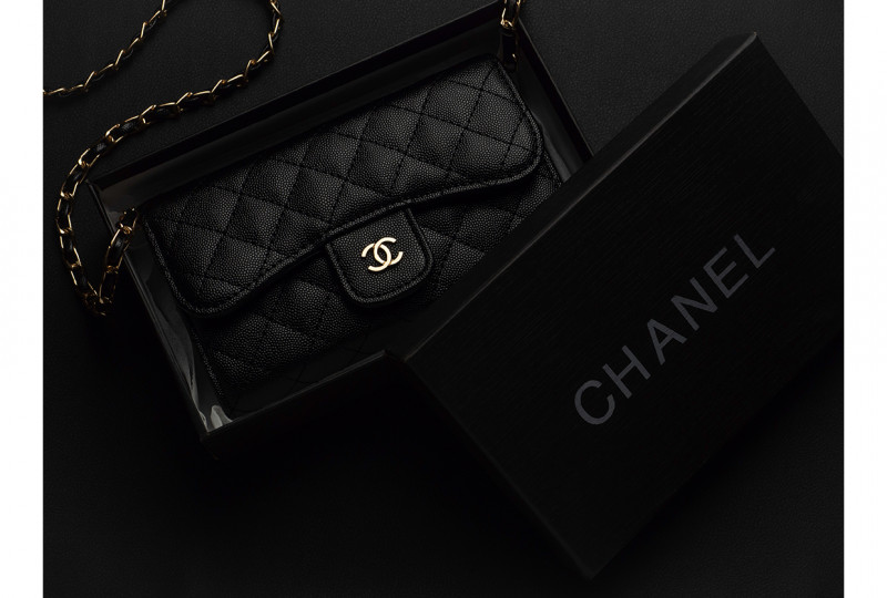 Chiang Rai, Thailand: September 30, 2019 - Close-up and top view of Chanel elegance women's accessories fashion black shoulder leather bag with golden chain in box.
